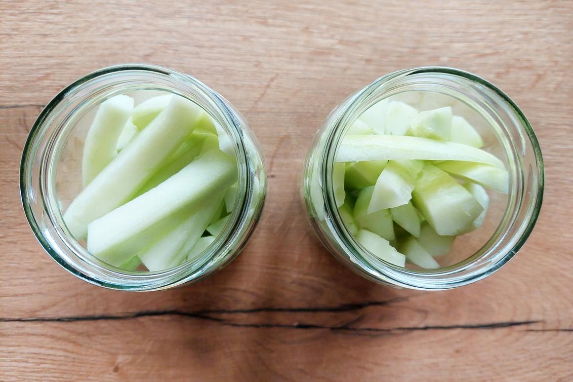 Gurken in Gläser geben
