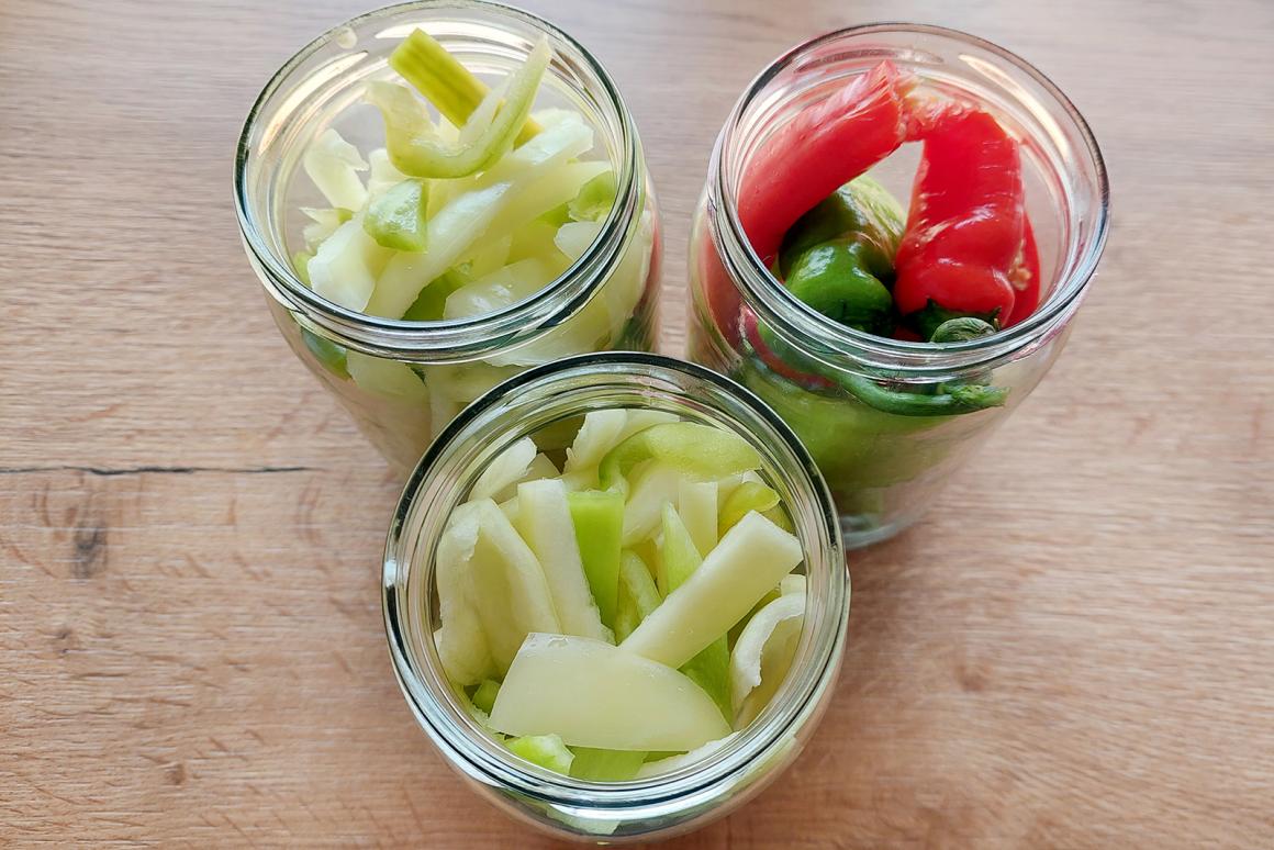 Peperoni in Gläser geben