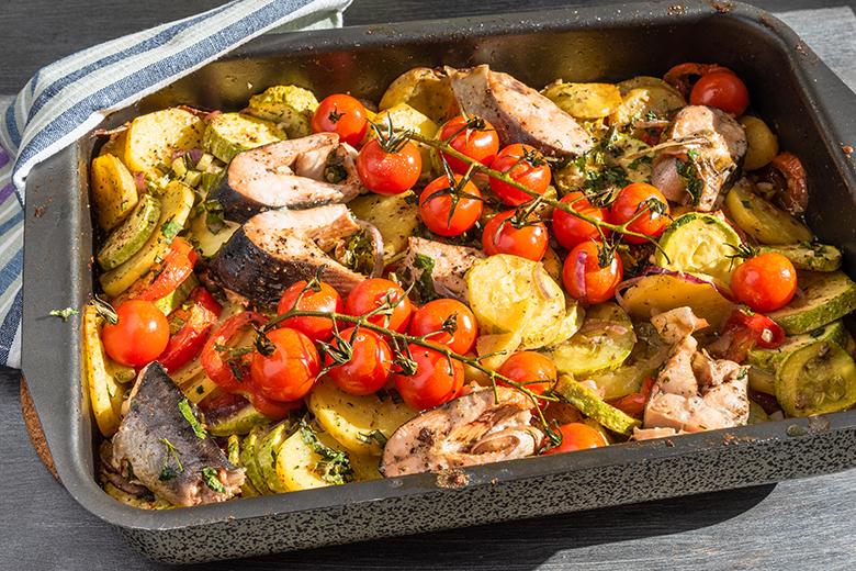 Gebratene Fischstücke mit Gemüse im Blech