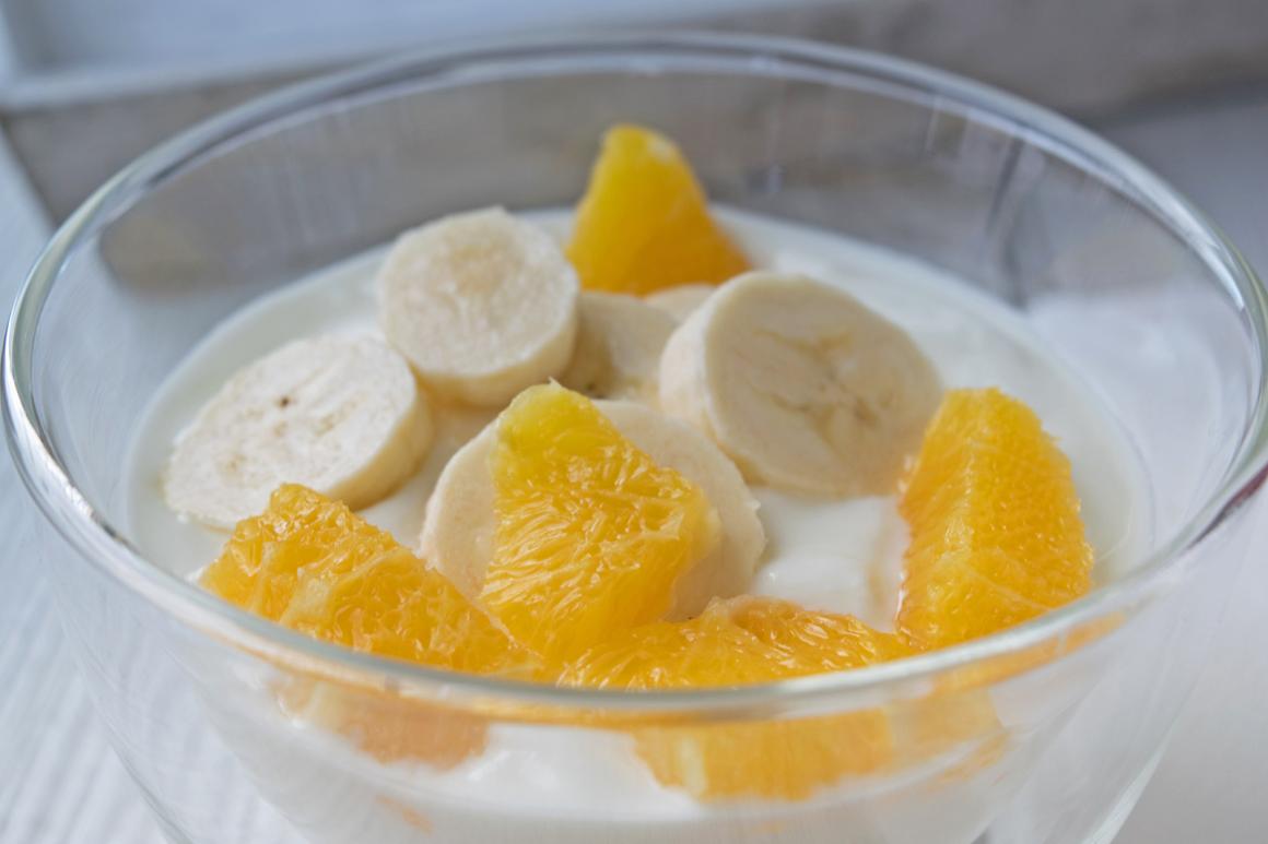 Frischer Joghurt-Becher mit Bananen und Orangen
