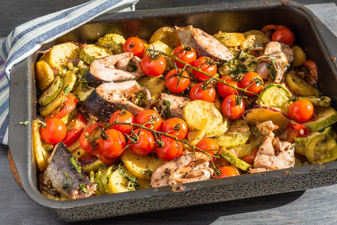 Gebratene Fischstücke mit Gemüse im Blech