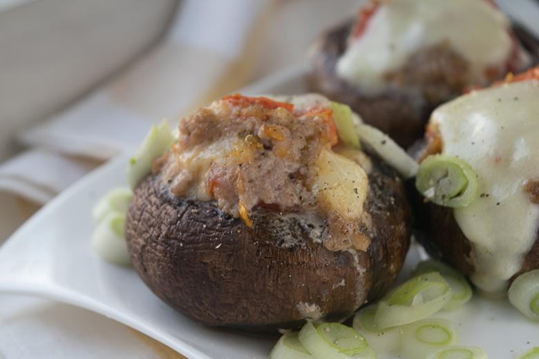 Mit Bratwurst gefüllte Champignons