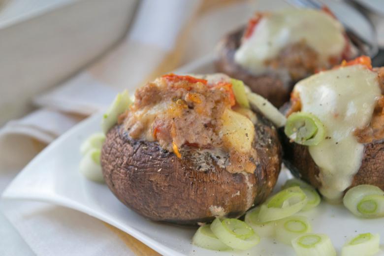 Mit Bratwurst gefüllte Champignons